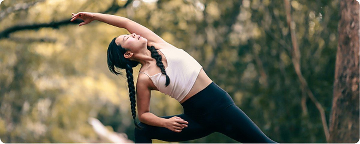 Woman practising yoga outdoors in the forest